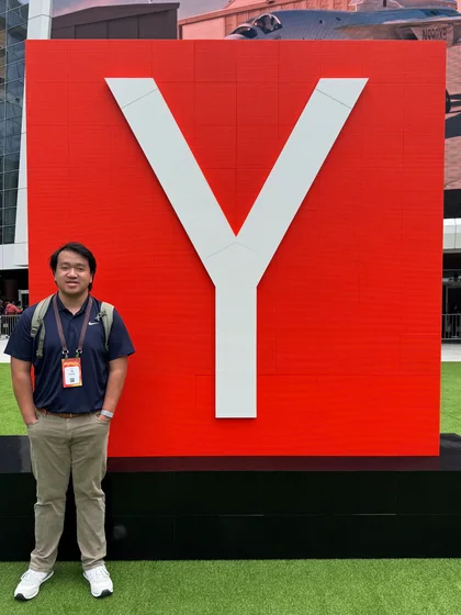 Zachary standing beside a large Y at Startup School